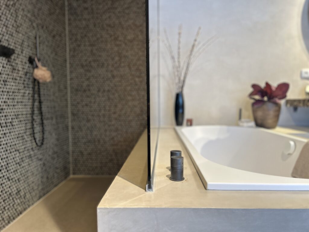 Detail badkamer met inloopdouche en elegante tegel met ingebouwd bad